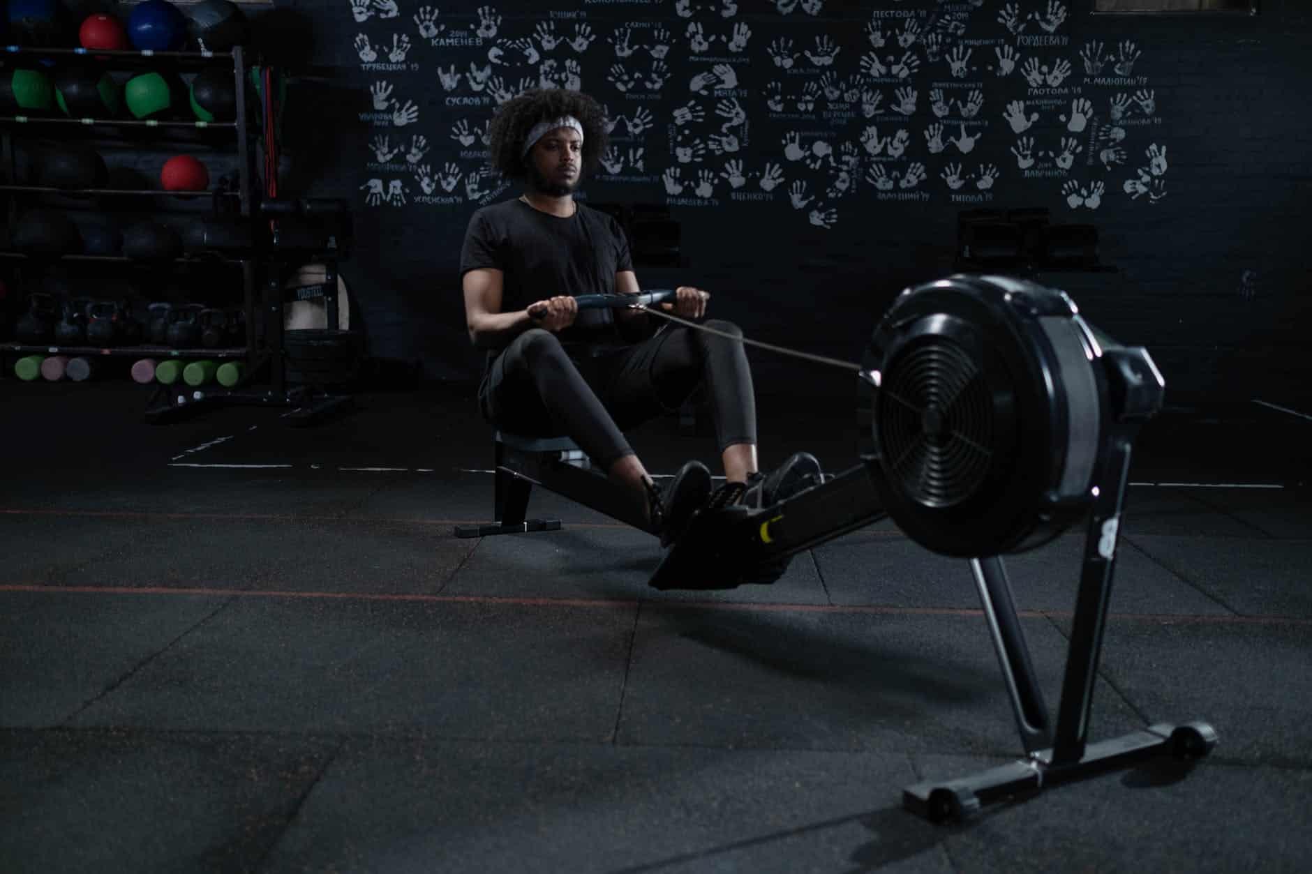 man in black activewear using a rowing machine