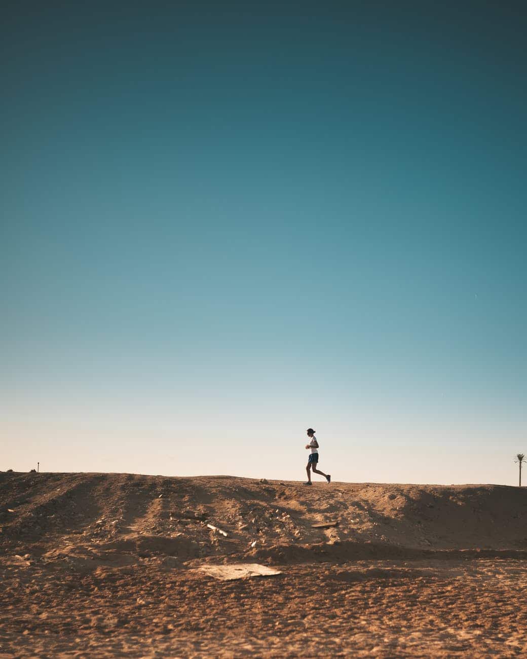 photo of person running on dirt road