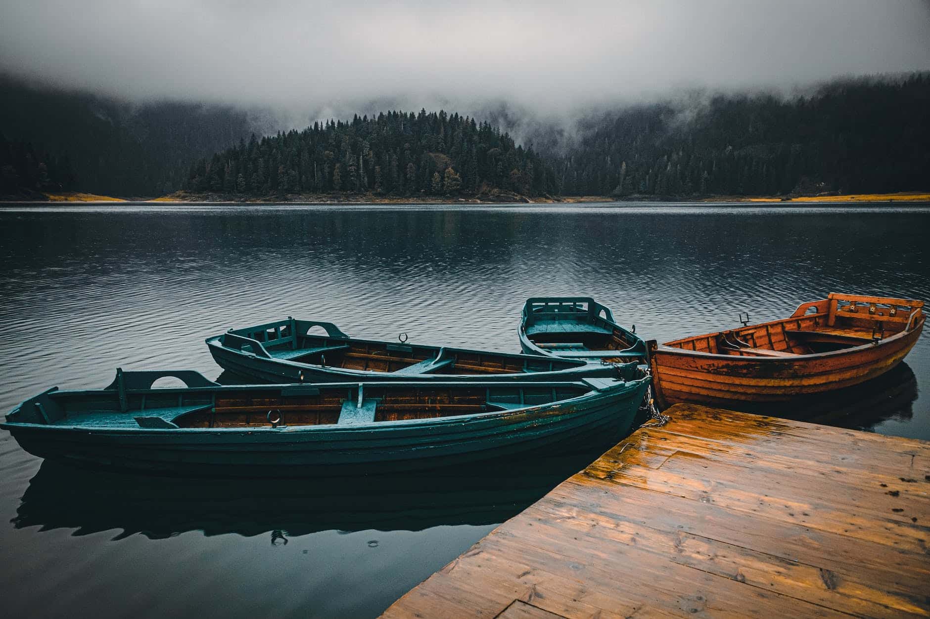 photo of wooden rowboats on a lake